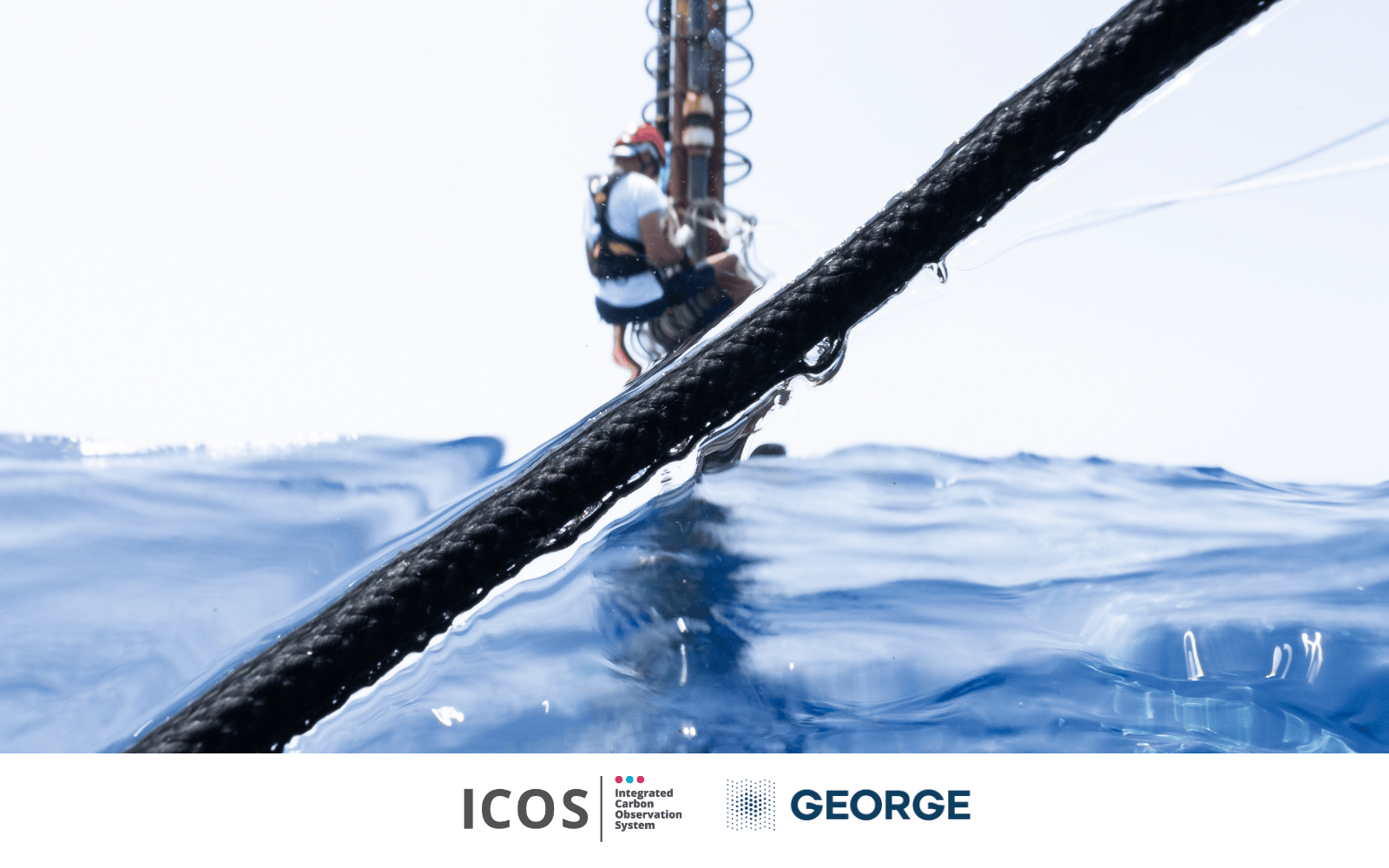 photo of seawater surface with a man working on a measurement tower on the background