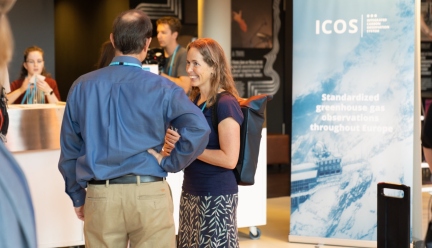 scientists interacting in front of an ICOS roll up 